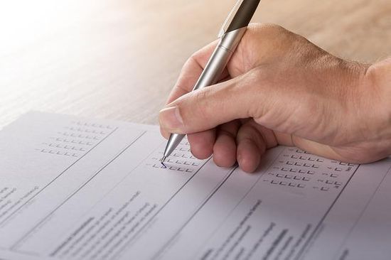 Someone checks off a box on a questionnaire.