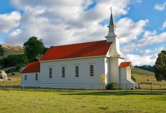 Old Red and White Church  A small country church surrounded by fields.