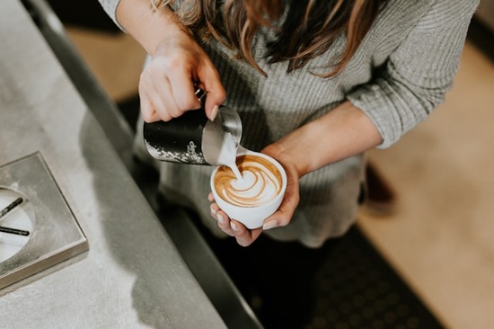 Barista preparing a latte in a coffee shop Going to a coffee shop is one way to reward yourself. It can feel special when watching a barista prepare a latte.