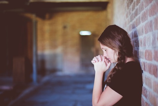 Woman praying Woman praying with folded hands as we learn that we can pray for anything we need and share everything with God