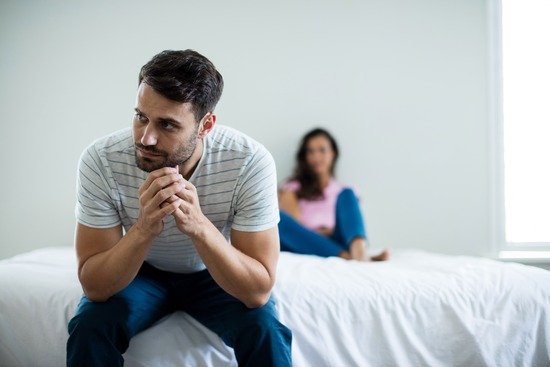 Man Frustrated at Wife A man facing away from his wife in frustration over an argument