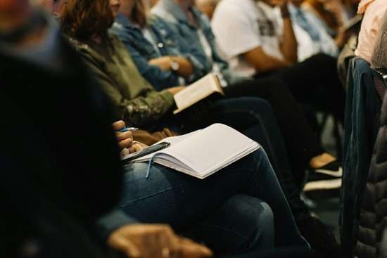 People taking notes in church People seated in church with their Bibles and notebooks open. They are taking notes and learning about the Bible with each other.