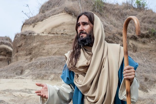 Jesus' Life as Shepherd of the People Jesus holding a shepherd's staff in one hand and reaching out with the other hand