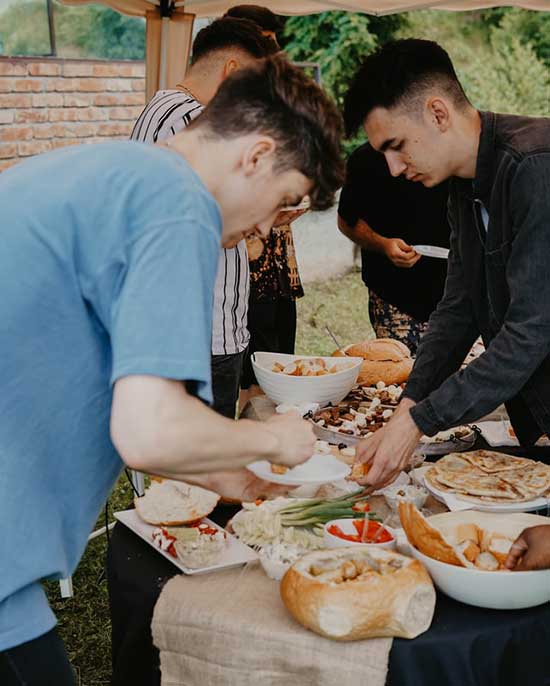 Serving food at potluck A man putting food on his plate at a potluck
