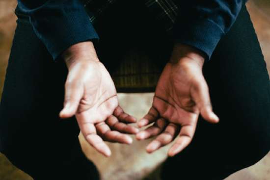 Holding hands up A man holding his hands upward in prayer to God