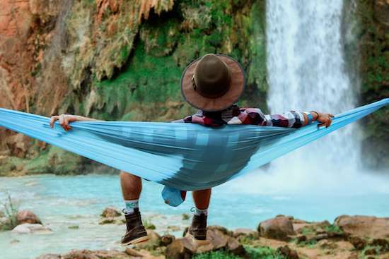Man Resting in Hammock Sabbath A man resting in a hammock at the base of waterfall on Sabbath