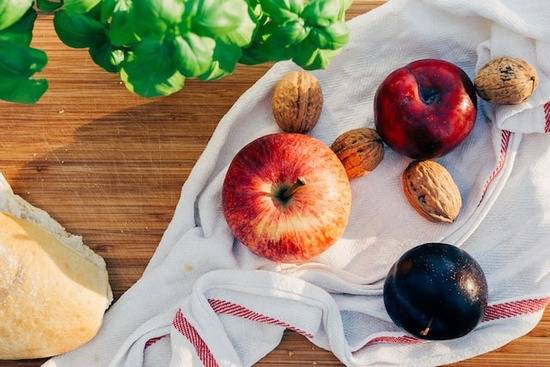 Nuts and Fruits An assortment of plant foods on a cloth: apple, plum, nuts, bread, and basila meal after deciding to give up meat eating