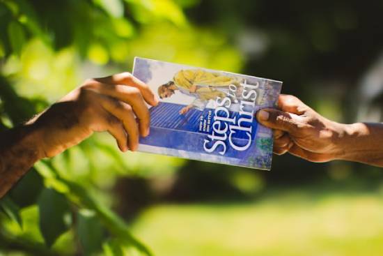 A person hands out a copy of the book 