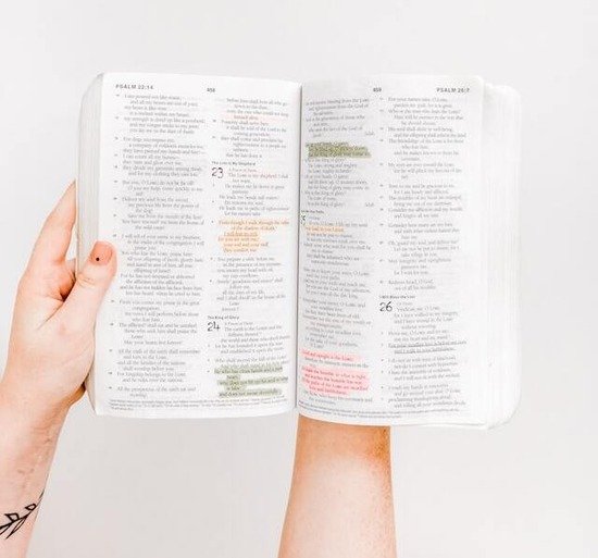 Open Bible A hand holding an open Bible and claiming God's promises to resist temptation