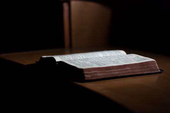 Bible Open on a Desk An open Bible lying on a desk