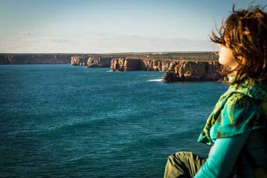 Woman sitting on a cliff A woman sitting on a cliff near the sea and enjoying the Sabbath