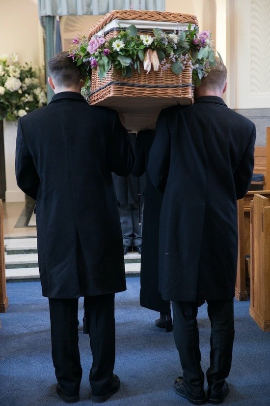 Casket of Dead Person Two men in black suits carrying a casket of a dead person
