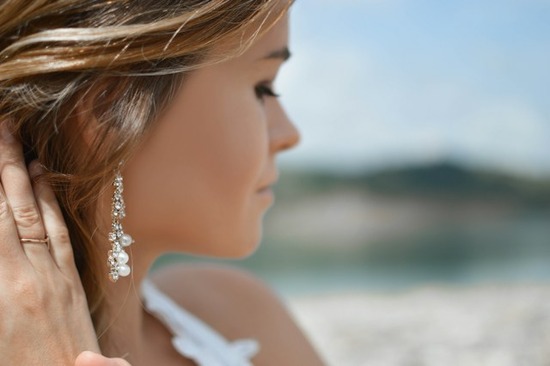 Woman wearing ornate earrings and a ring A woman pulling back her hair to reveal earrings as a sign of outward adornment