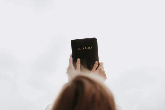 Woman holding Bible A woman lifting a Bible up to the sky