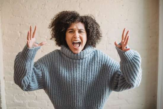 Woman Yelling A woman with her hands up, yelling